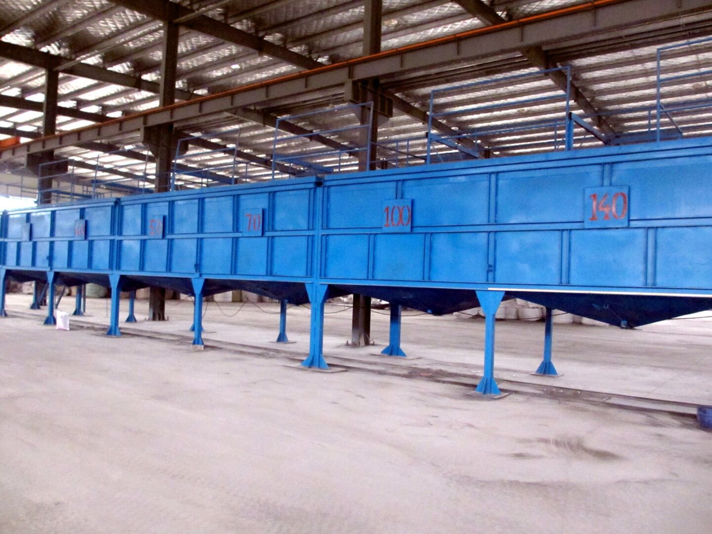 A large blue machine in an empty warehouse.